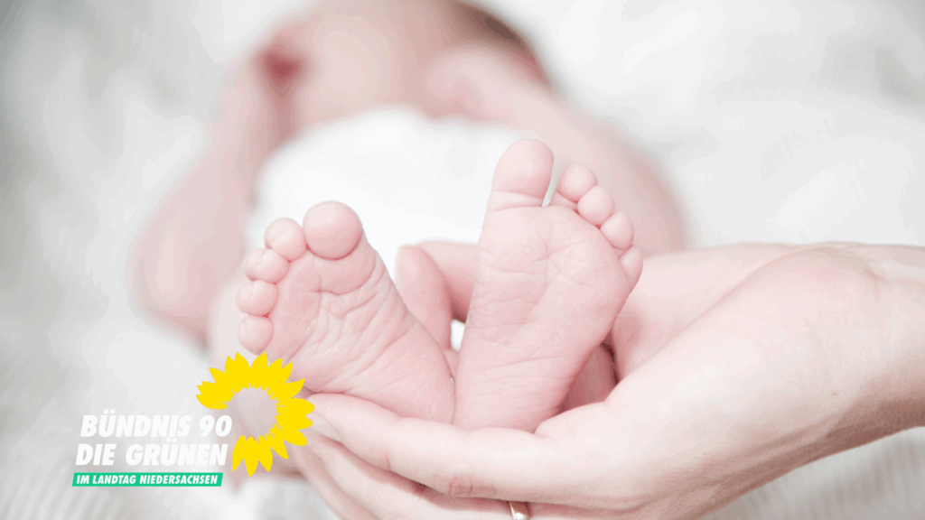 Zwei kleine Babyfüsse werden von einer erwachsenen Hand liebevoll gehalten.